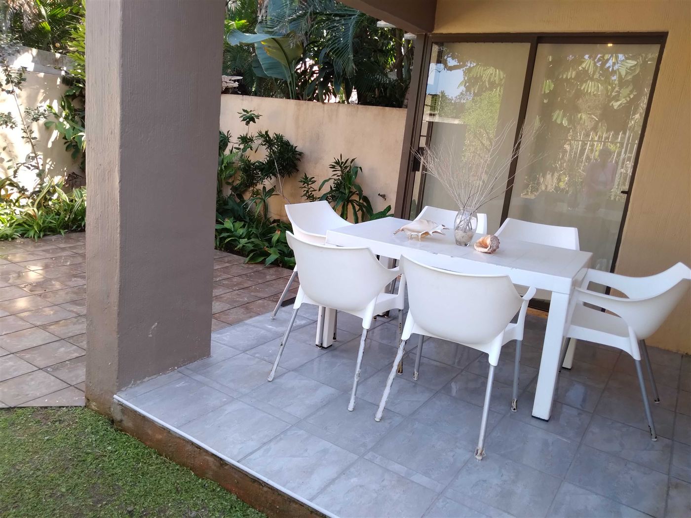 Shaded patio with white table and chairs